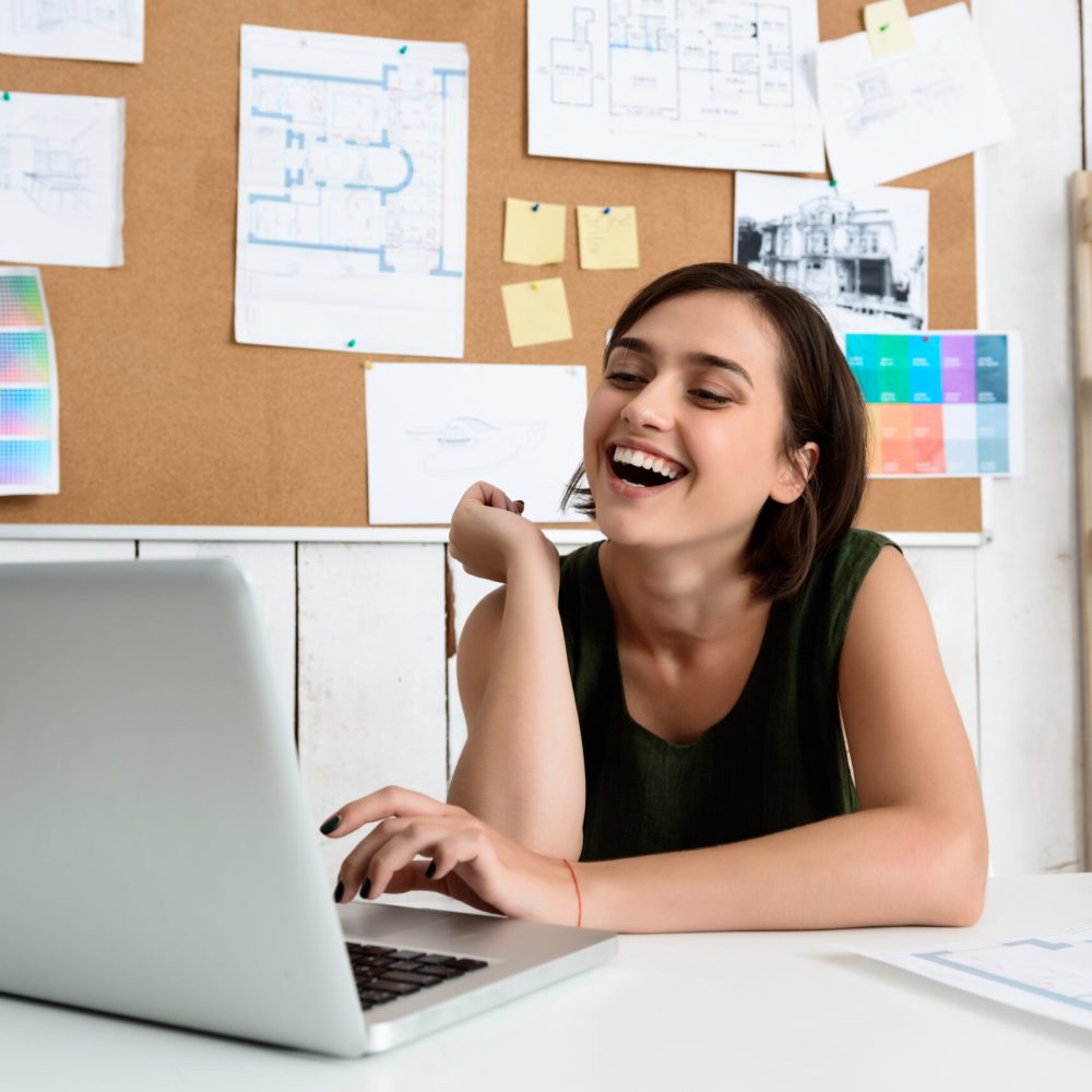 Young beautiful businesswoman smiling, sitting at workplace typing on laptop in office.